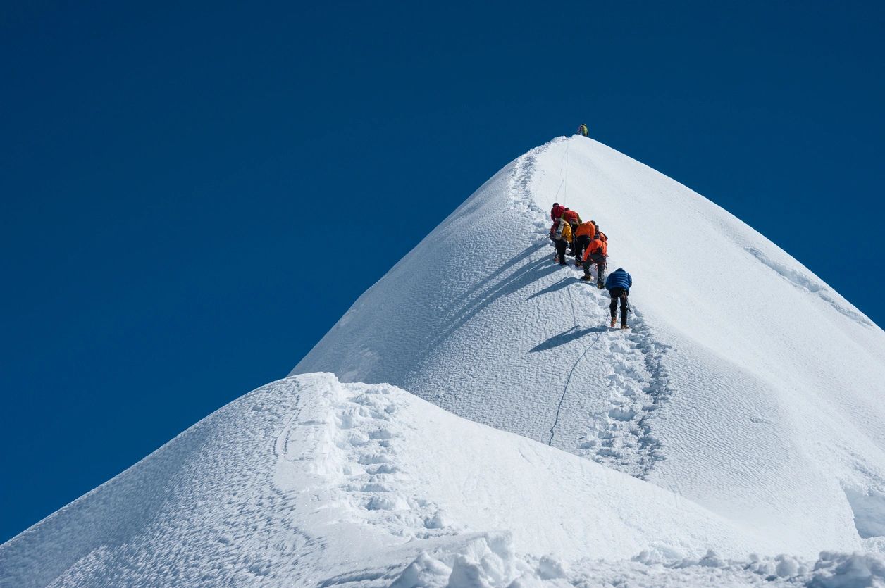 Mountaineers ascending a snowy peak